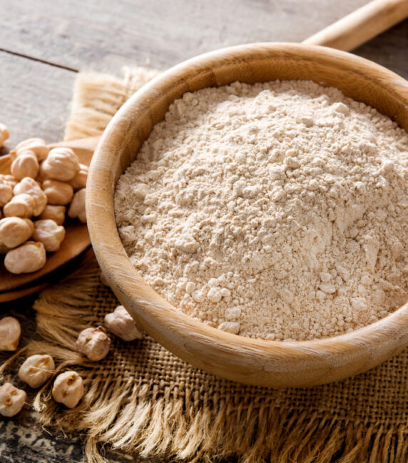 Chickpea flour in wooden bowl on wooden table