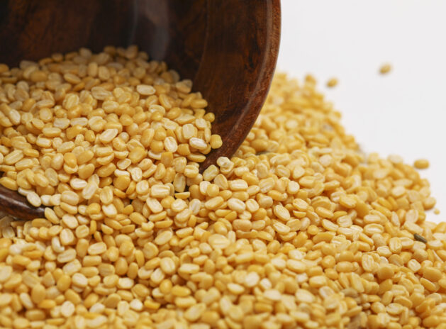 yellow moong mung dal lentil pulse bean in wooden bowl on white background